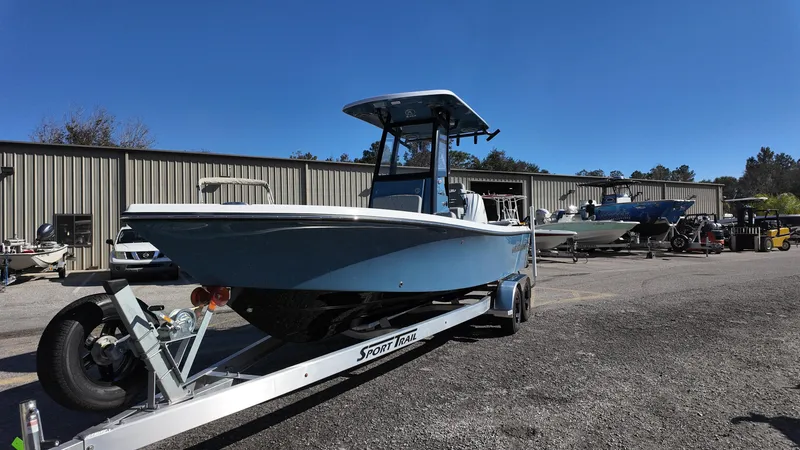 Slide: The Image of 2025 Blazer 2440 boat on trailer, parked outdoors under clear blue sky. - 25