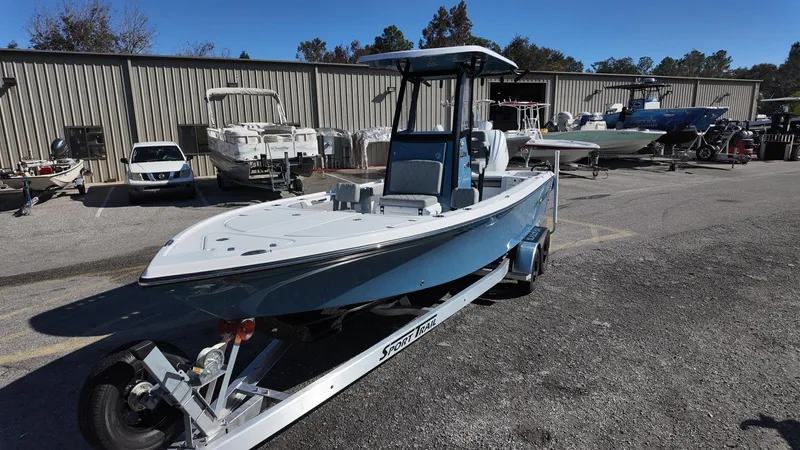 Slide: The Image of 2025 Blazer 2440 boat on trailer, parked outdoors near other boats. - 26