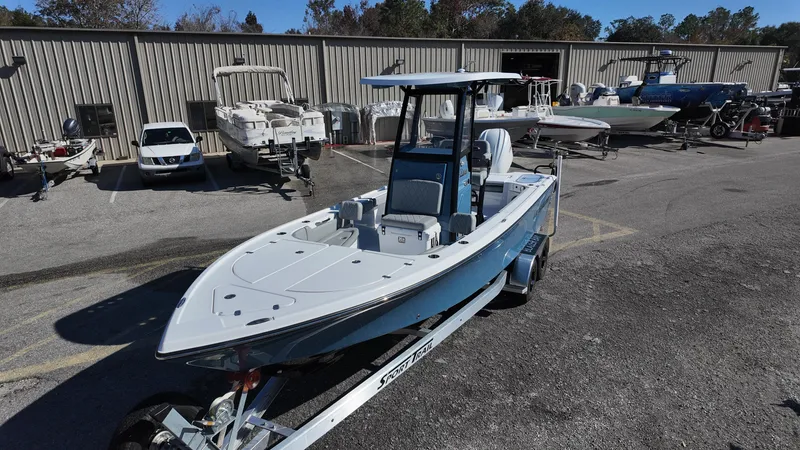 Slide: The Image of 2025 Blazer 2440 boat on trailer at marina, surrounded by other boats. - 27