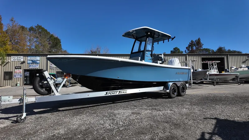 Slide: The Image of 2025 Blazer 2440 boat on trailer, parked outdoors under clear blue sky. - 28