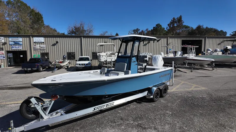 Slide: The Image of 2025 Blazer 2440 boat on trailer in dealership lot, surrounded by other boats. - 30