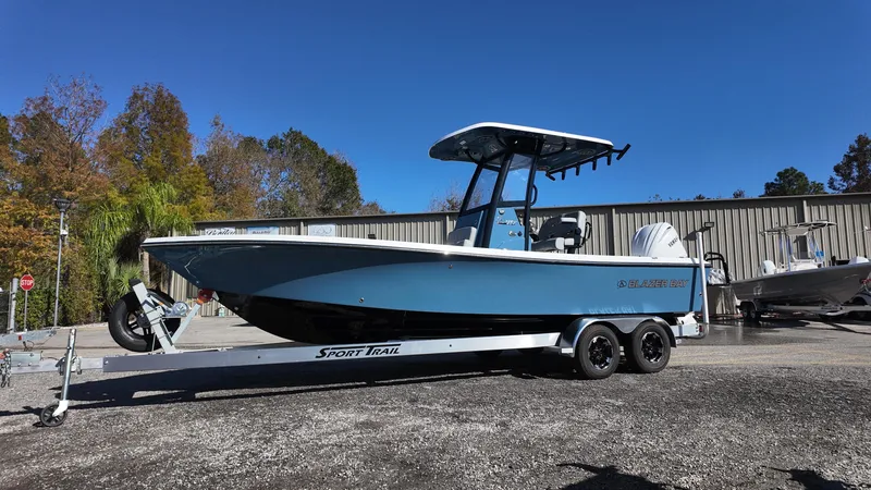 Slide: The Image of 2025 Blazer 2440 boat on trailer, parked outdoors, clear sky background. - 32