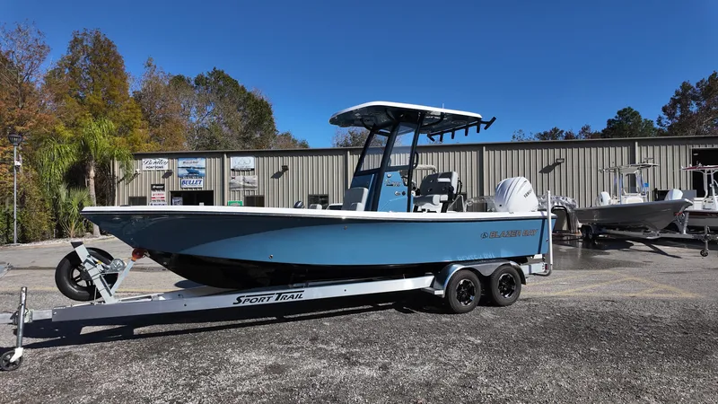 Slide: The Image of 2025 Blazer 2440 boat on trailer, parked outdoors near a building. - 33
