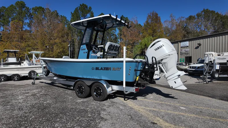 Slide: The Image of 2025 Blazer 2440 boat with Yamaha engine on trailer, parked outdoors. - 38