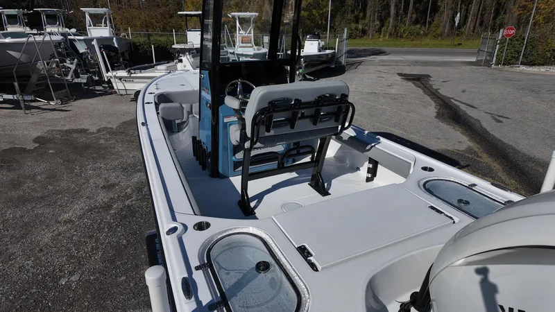 Slide: The Image of 2025 Blazer 2440 boat interior with seating and storage, parked outdoors. - 43