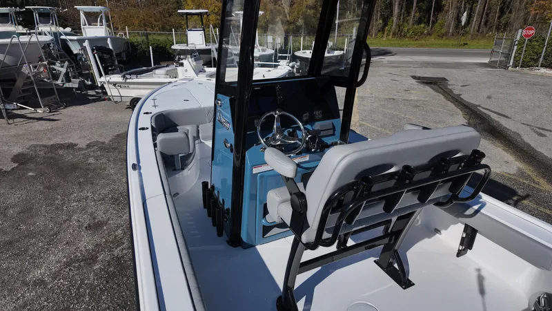 Slide: The Image of 2025 Blazer 2440 boat interior with steering console and seating, parked outdoors. - 44
