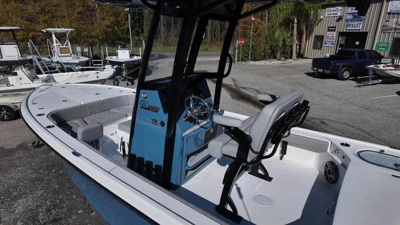 Slide: The Image of 2025 Blazer 2440 boat with blue console and seating, parked outdoors. - 45