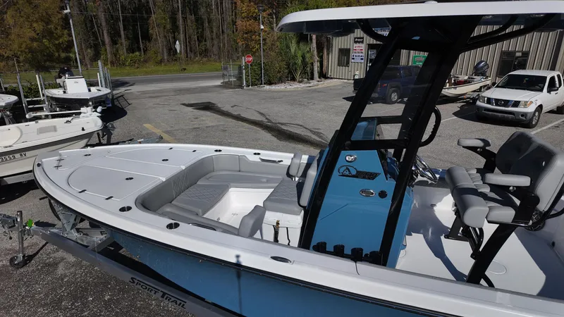 Slide: The Image of 2025 Blazer 2440 boat with blue console, parked on a trailer in a lot. - 47