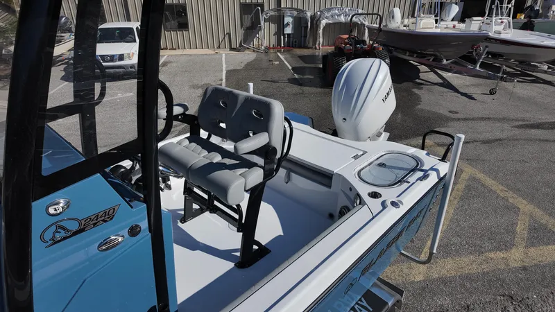 Slide: The Image of 2025 Blazer 2440 boat interior with seating and outboard motor in a marina setting. - 49