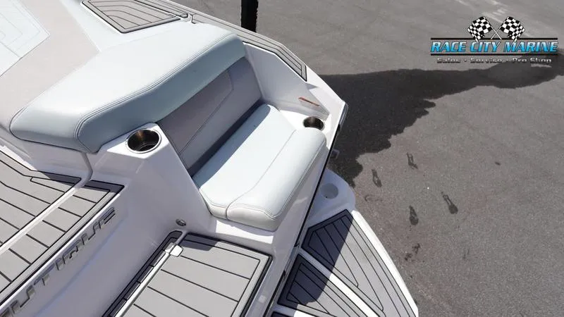 Slide: The Image of 2021 Nautique Super Air Nautique G23 boat seating with cup holders, Race City Marine logo. - 12