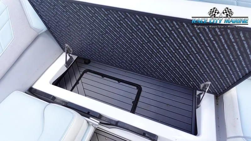 Slide: The Image of 2021 Nautique Super Air Nautique G23 storage compartment, open with Race City Marine logo. - 23