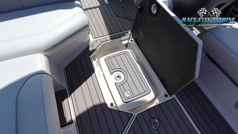 Slide: The Image of 2021 Nautique Super Air Nautique G23 interior storage compartment, featuring sleek gray seating and flooring. - 28