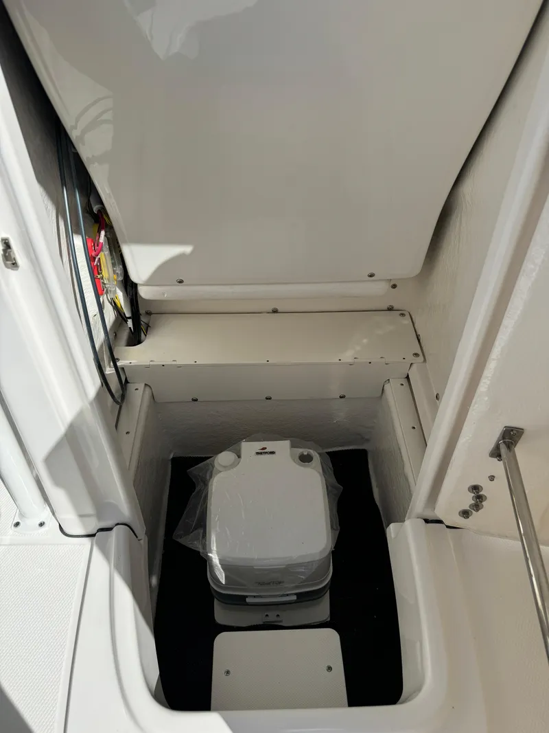 Slide: The Image of 2025 Robalo R200 Center Console boat interior with compact marine toilet. - 12