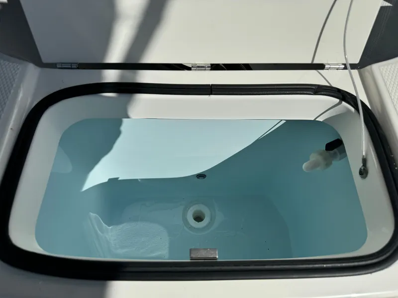 Slide: The Image of 2025 Robalo R200 Center Console livewell with water, open lid view. - 19