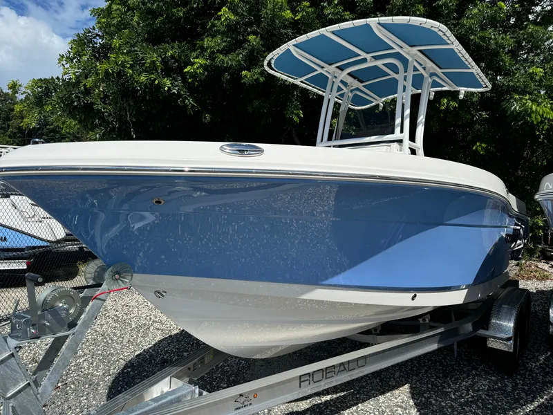 Slide: The Image of 2025 Robalo R200 Center Console boat on trailer, blue and white design. - 2