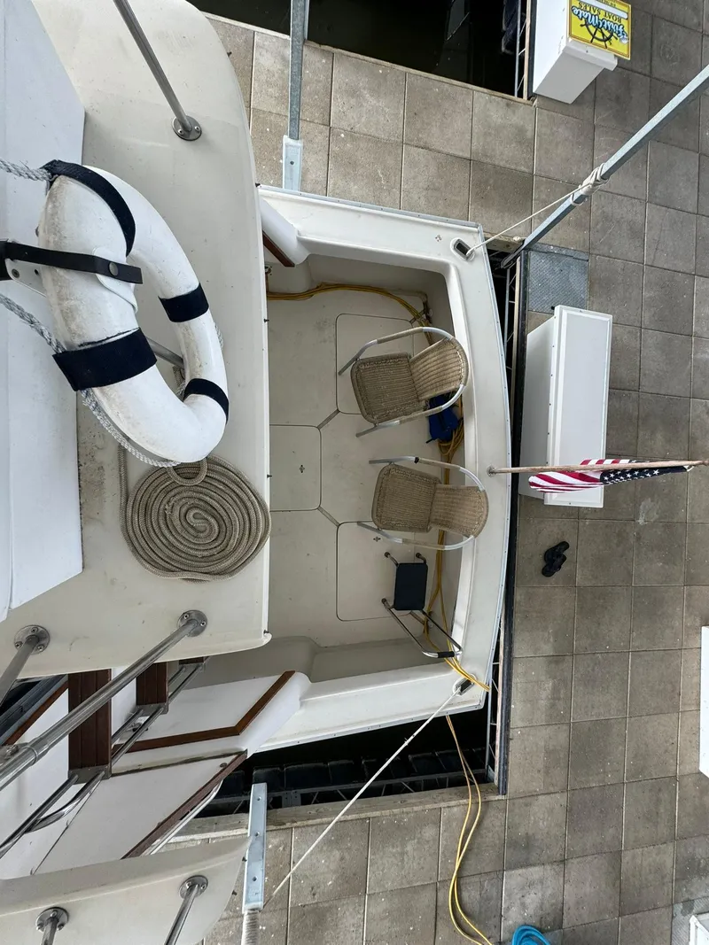 Slide: The Image of 1986 Silverton 34 Convertible boat deck with chairs, life preserver, and American flag. - 10