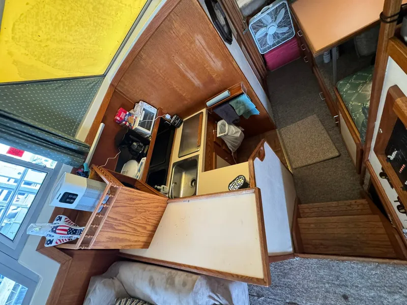 Slide: The Image of Interior of 1986 Silverton 34 Convertible boat, featuring kitchen and living area. - 12