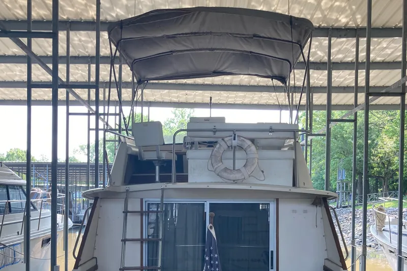 Slide: The Image of 1986 Silverton 34 Convertible boat docked under a covered marina. - 18