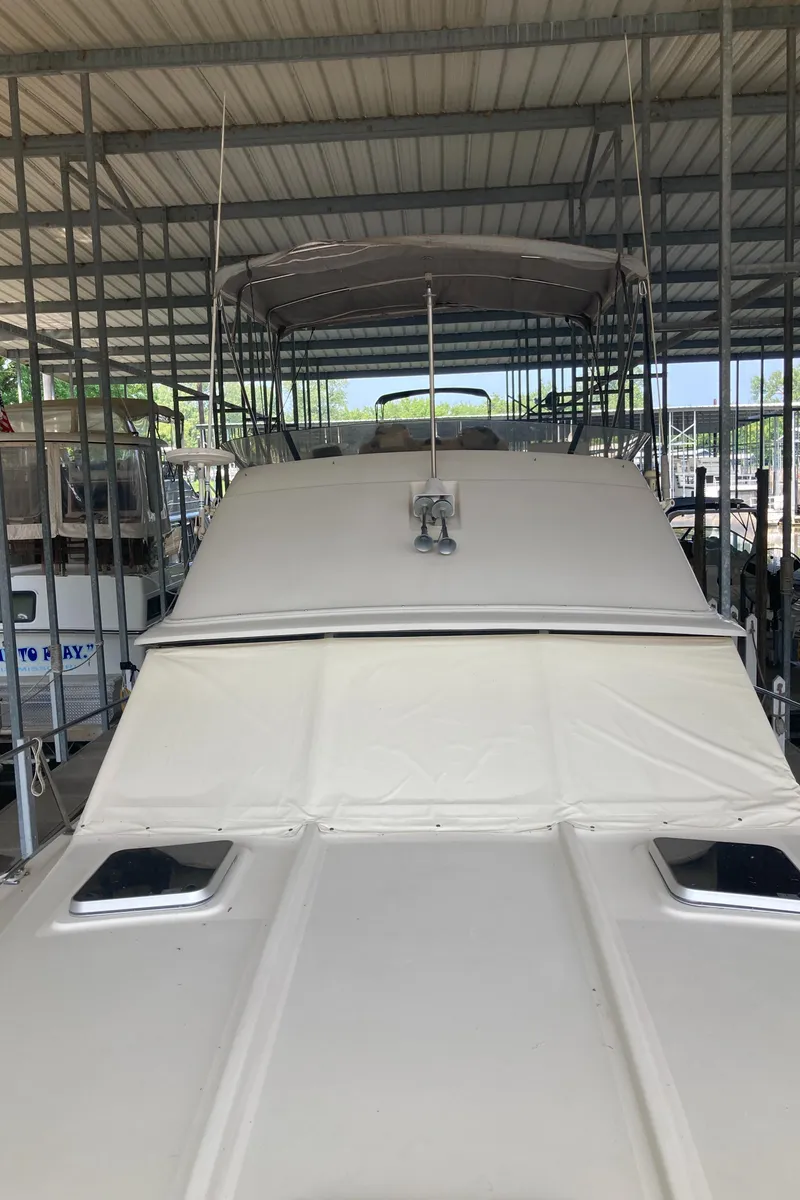 Slide: The Image of 1986 Silverton 34 Convertible boat docked in a covered marina. - 19