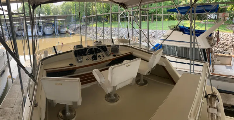 Slide: The Image of 1986 Silverton 34 Convertible boat interior with helm and seating, docked in a marina. - 21