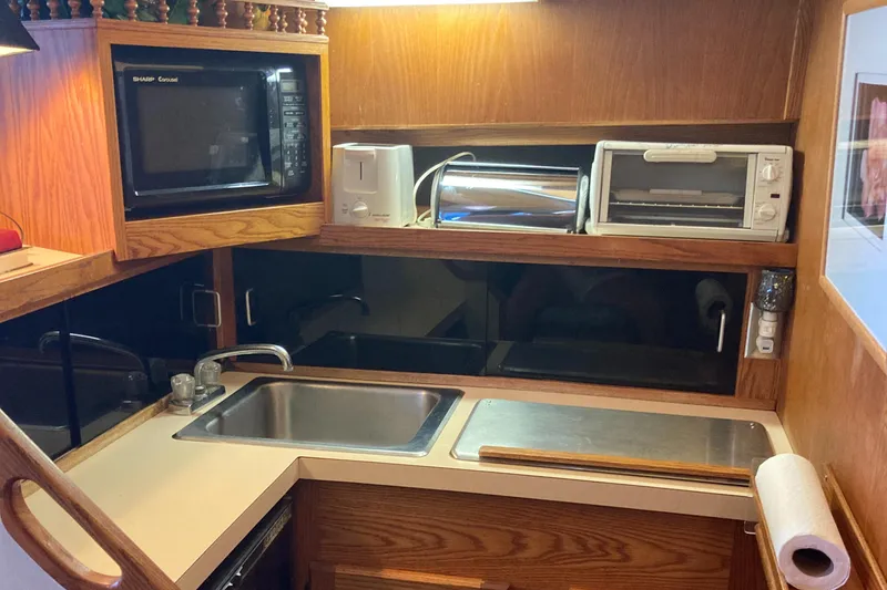 Slide: The Image of 1986 Silverton 34 Convertible kitchen with microwave, toaster, and sink. - 24