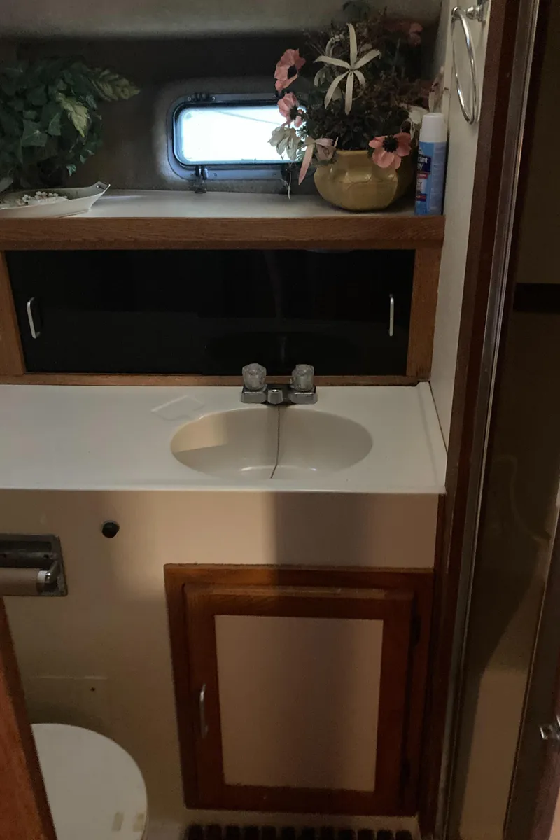 Slide: The Image of 1986 Silverton 34 Convertible bathroom with sink, wooden cabinet, and decorative plants. - 25