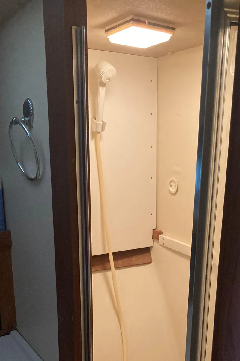 Slide: The Image of Shower area inside a 1986 Silverton 34 Convertible boat, featuring a compact design. - 26