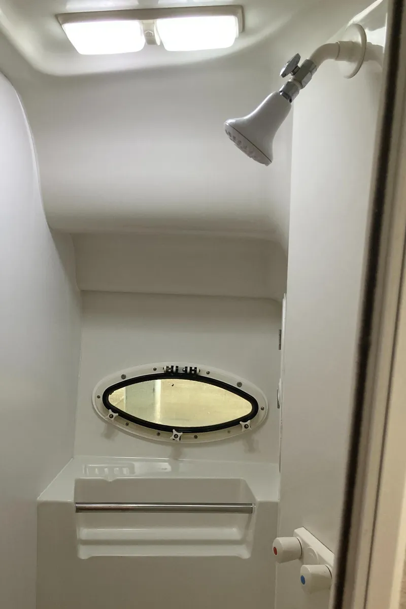 Slide: The Image of 1986 Silverton 34 Convertible boat shower with oval window and overhead lighting. - 27