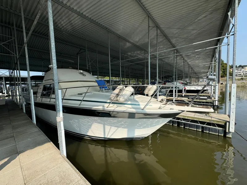 Slide: The Image of 1986 Silverton 34 Convertible boat docked under a covered marina. - 3