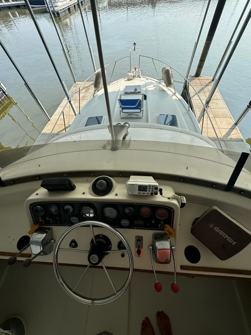 Slide: The Image of 1986 Silverton 34 Convertible boat helm with controls, docked at marina. - 4
