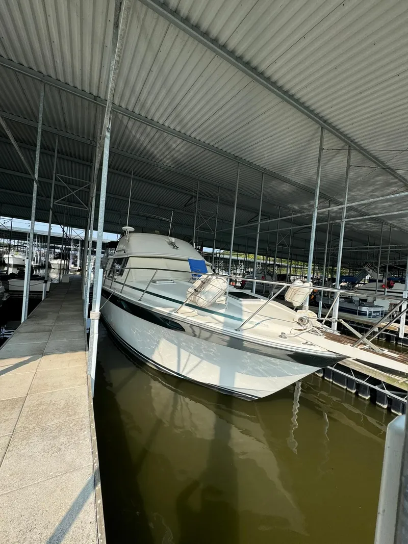 Slide: The Image of 1986 Silverton 34 Convertible docked in a covered marina. - 6