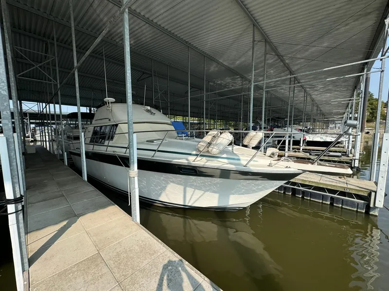 Slide: The Image of 1986 Silverton 34 Convertible boat docked under covered marina. - 7
