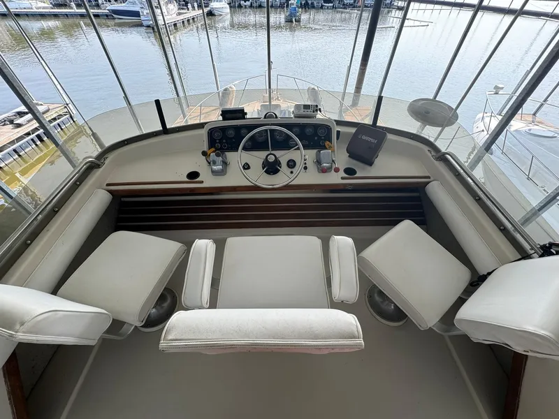 Slide: The Image of 1986 Silverton 34 Convertible boat helm with white seating and marina view. - 8
