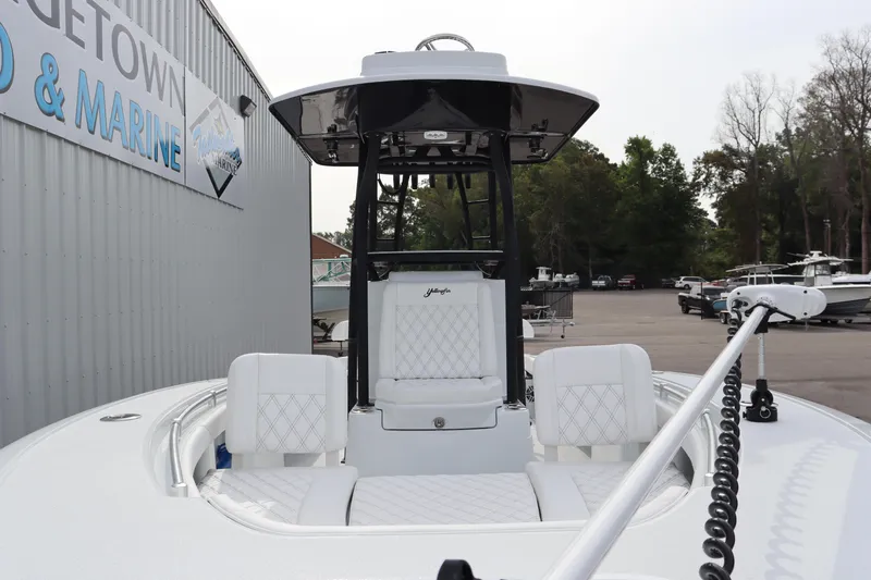 Slide: The Image of 2025 Yellowfin 26 Hybrid boat with white seating, docked at a marina. - 8
