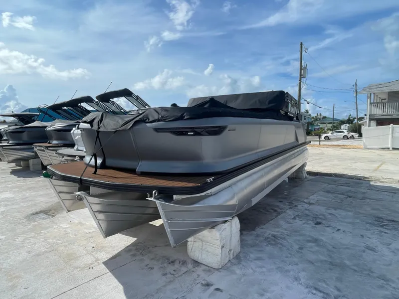 Slide: The Image of 2025 Manitou 26 Explore Switchback pontoon boat, covered and docked outdoors. - 3