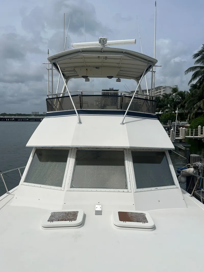 Slide: The Image of 1985 Hatteras 45 Convertible yacht docked, front view with flybridge and windows. - 18