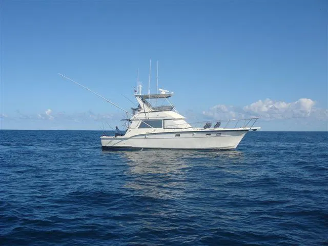 Slide: The Image of 1985 Hatteras 45 Convertible yacht on open sea under clear blue sky. - 2