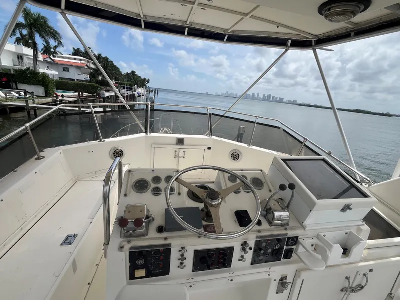 Slide: The Image of 1985 Hatteras 45 Convertible yacht helm with ocean view and city skyline. - 26