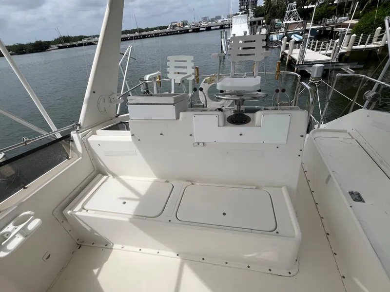 Slide: The Image of 1985 Hatteras 45 Convertible boat deck with seating, overlooking marina. - 27