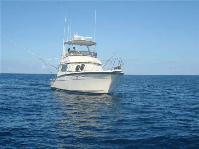 Slide: The Image of 1985 Hatteras 45 Convertible yacht on open sea under clear blue sky. - 3