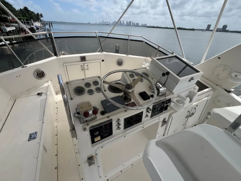 Slide: The Image of Helm of 1985 Hatteras 45 Convertible yacht with ocean view and city skyline. - 37