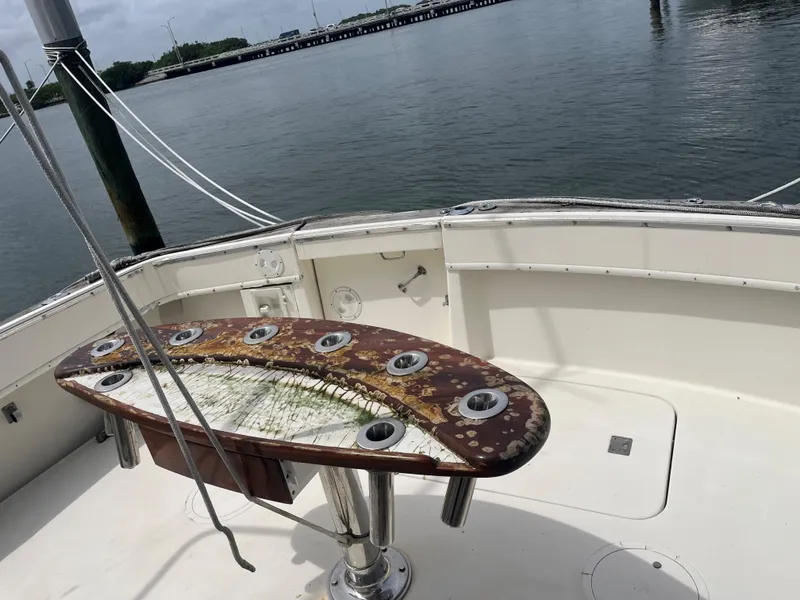 Slide: The Image of 1985 Hatteras 45 Convertible fishing deck with rod holders, overlooking calm waters. - 47
