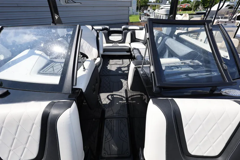 Slide: The Image of 2021 Tigé 23ZX boat interior with white and black seating, open layout. - 14
