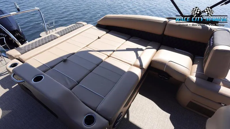 Slide: The Image of 2025 Barletta L23U pontoon boat with spacious tan seating on a calm lake. - 18
