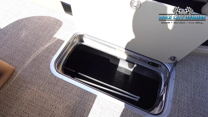 Slide: The Image of 2025 Barletta L23U boat storage compartment with open hatch, featuring carpeted flooring. - 26