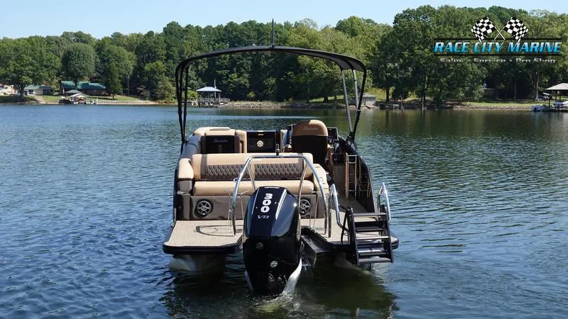 Slide: The Image of 2025 Barletta L23U pontoon boat on a serene lake with lush green surroundings. - 4