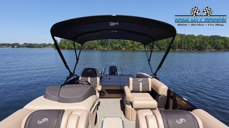 Slide: The Image of 2025 Barletta L23U pontoon boat on a serene lake with lush green shoreline. - 46