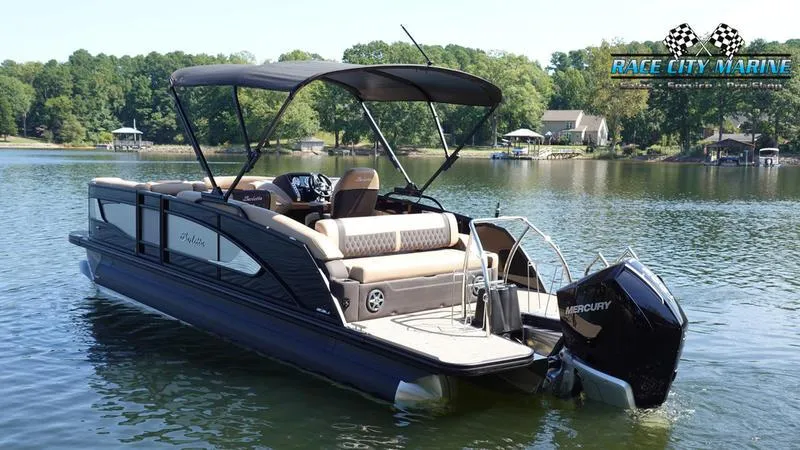 Slide: The Image of 2025 Barletta L23U pontoon boat on a serene lake with lush greenery. - 7