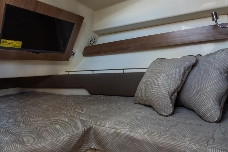 Slide: The Image of 2026 Chris-Craft Calypso 35 cabin interior with bed, pillows, and mounted TV. - 18