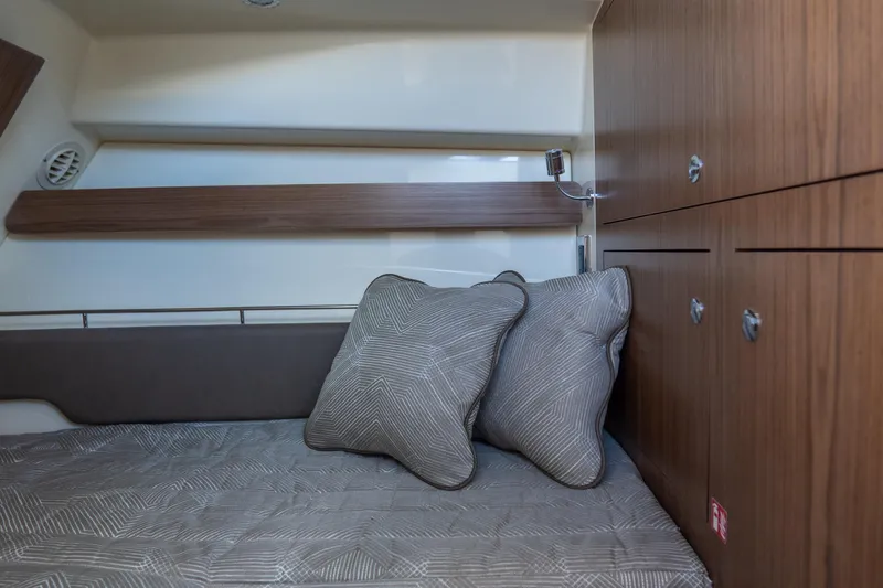 Slide: The Image of 2026 Chris-Craft Calypso 35 cabin interior with cozy bedding and wooden cabinetry. - 19